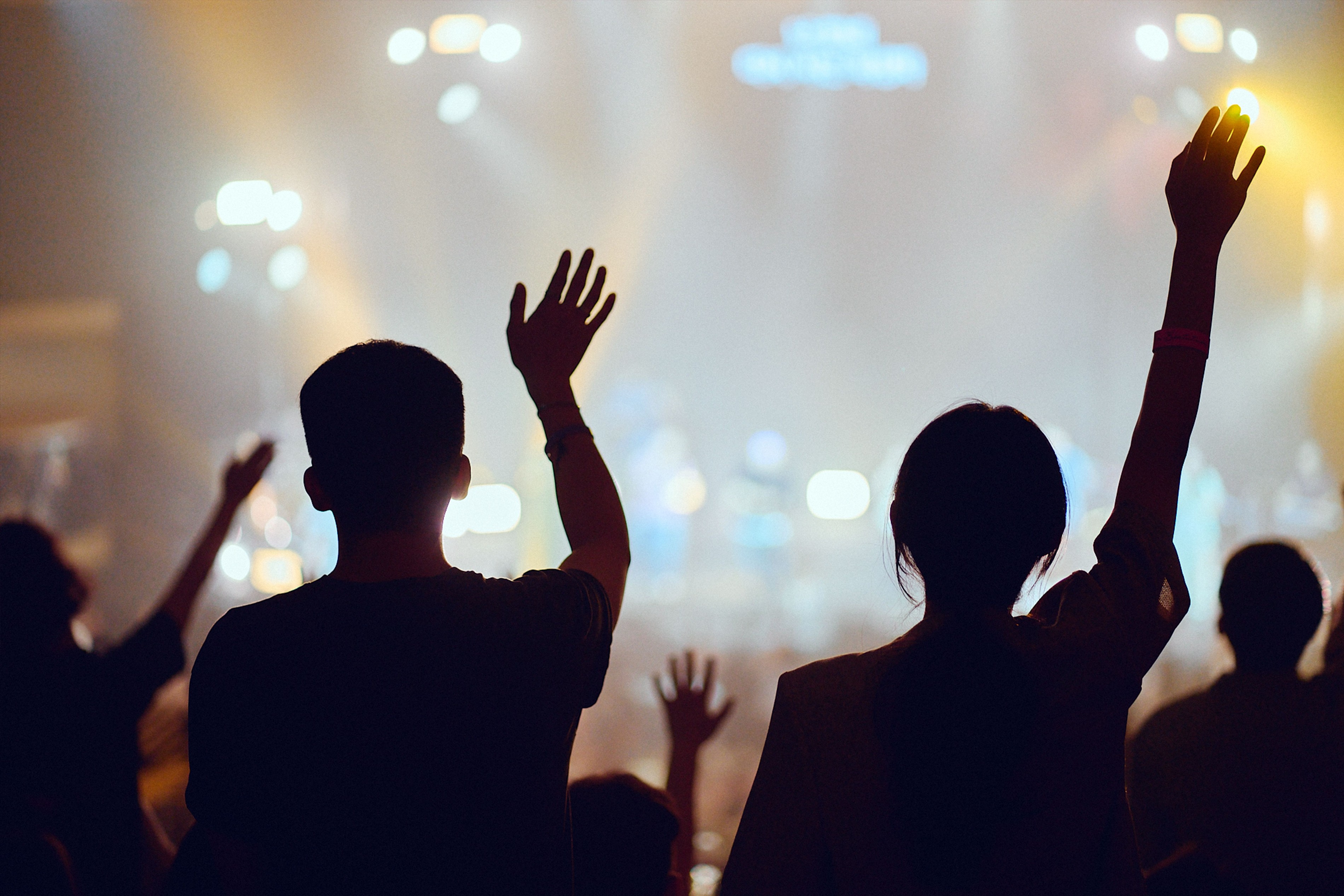 Picture of worshippers with hands raised in a large Korean church service