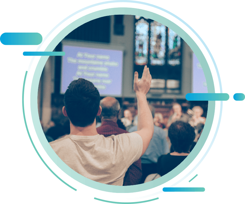 Picture of a worship service with a man worshiping and lyrics displayed from a projector